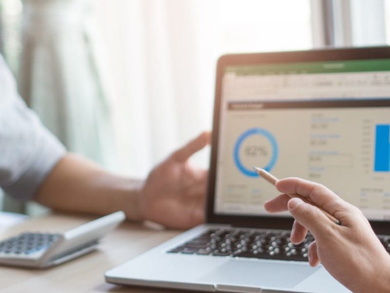 Weekly team meeting in the conference room. Close up view of business people in project pointing to laptop screen and  discussing budget financial for new project in meeting in workplace.