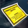 Penalty charge notice illegal parking fine attached to car windscreen