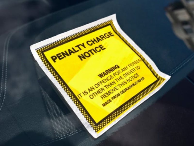 Penalty charge notice illegal parking fine attached to car windscreen